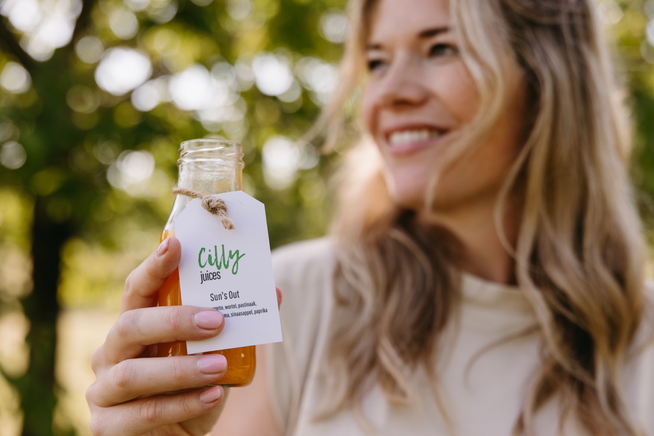 a woman holding a bottle of juice